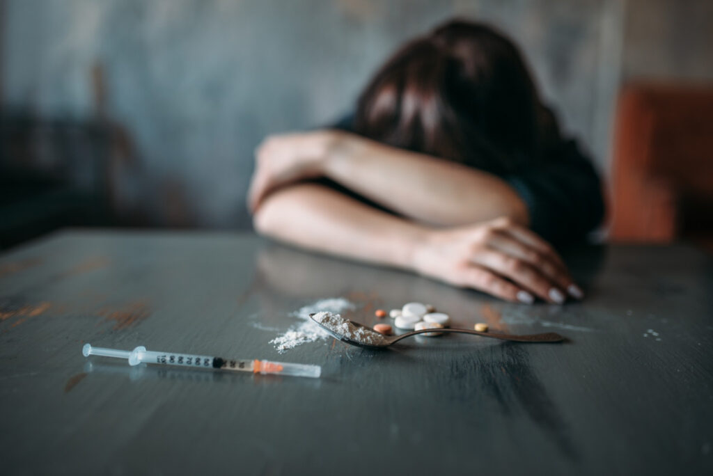 A young woman is experiencing an overdose after injecting heroin.