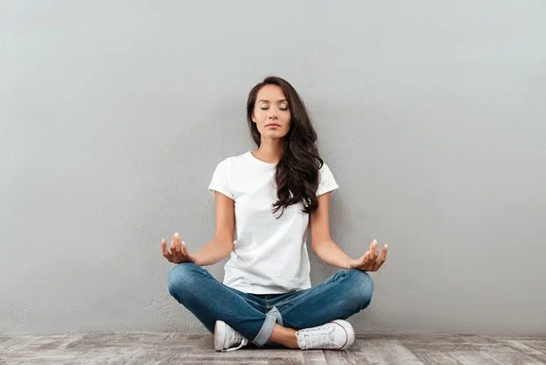 A woman practices meditation, one of the mindfulness based cognitive therapy techniques.
